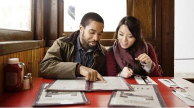 Man and woman look at menu
