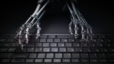 Robotic hands typing on computer keyboard