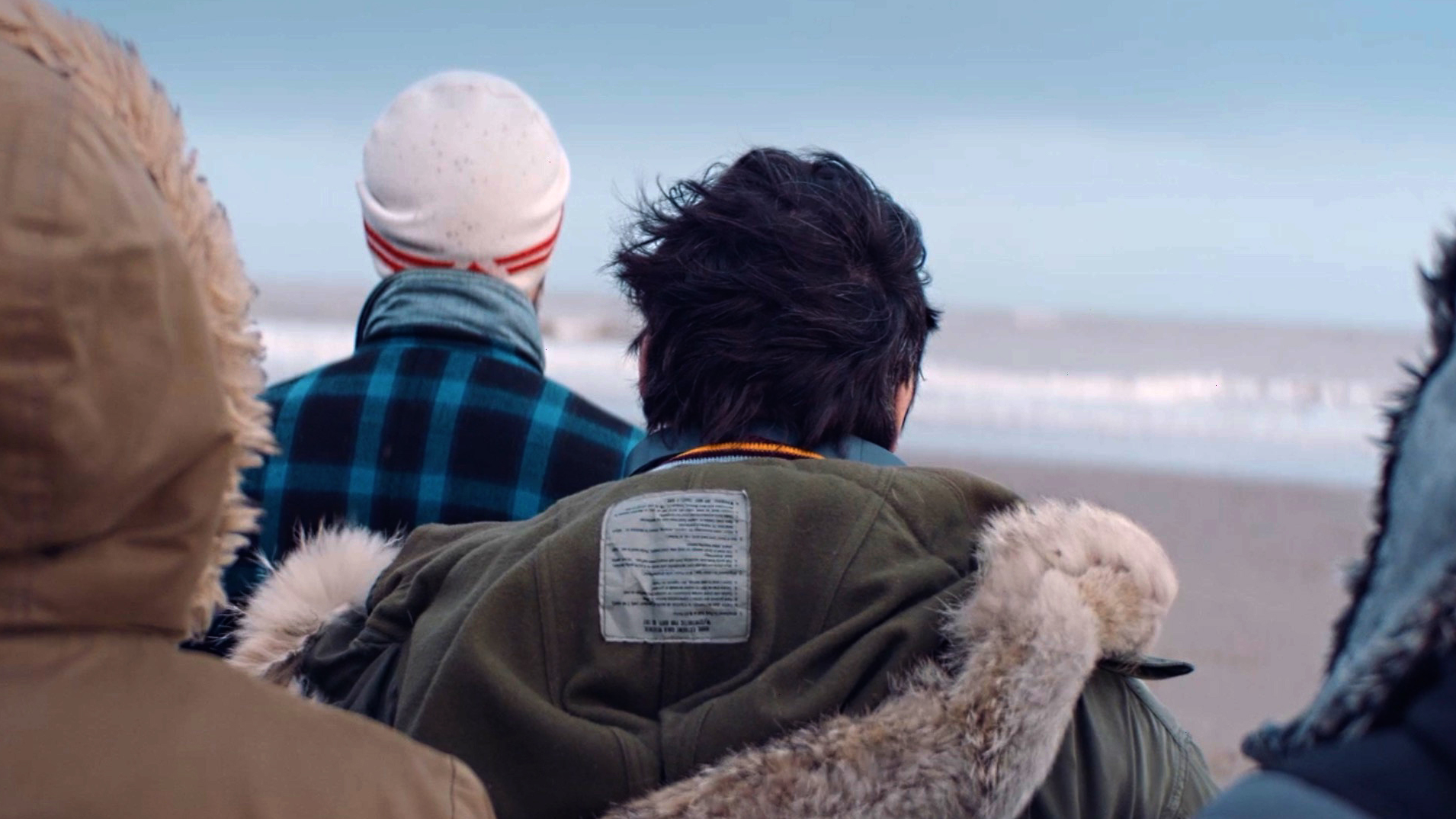 A shot of some people on a beach looking out to sea