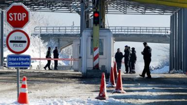 Kosovo and Serbian police stand at the Kosovo-Serbia border crossing of Merdare on December 10, 2012.