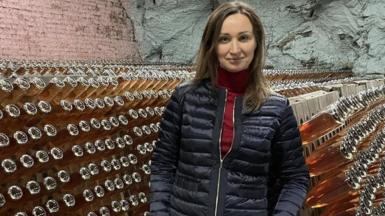 Oleksandra Cherednychenko standing in a wine cellar