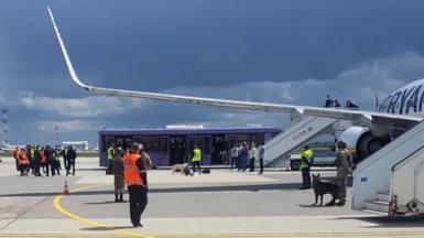 Το προσωπικό του αεροδρομίου και οι δυνάμεις ασφαλείας βρίσκονται στην άσφαλτο μπροστά από μια πτήση της Ryanair που αναγκάστηκε να προσγειωθεί στο Μινσκ της Λευκορωσίας.  Φωτογραφία: 23 Μαΐου 2021