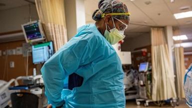 A medical workers puts on PPE before entering a negative pressure room at a US hospital.
