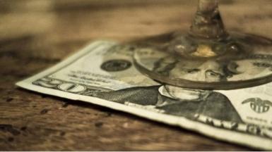 $20 bill under a wine glass