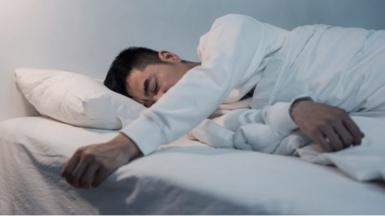 A man who appears to be unable to move in bed