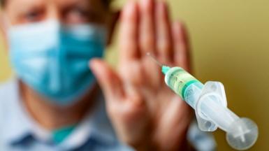photo illustration of a man waving away a needle