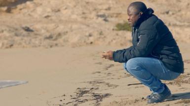 Thomas Naadi on the beach in Lampedusa