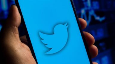 In this photo illustration the Twitter logo seen displayed on a smartphone