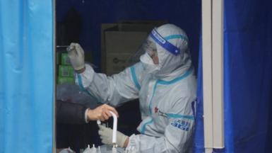 Medical worker collects a swab sample from a person at a makeshift testing site during the coronavirus disease (COVID-19) outbreak in Hong Kong