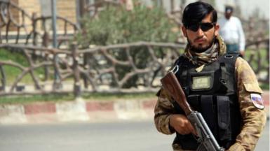 An Afghan security official stands guard at a check point in Lashkar Gah, the provincial capital of Helmand province, Afghanistan, 11 July 2021.