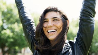 Woman looking happy with arms raised