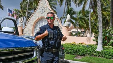 Law enforcement officers are seen in front of the home of former President Donald Trump at Mar-A-Lago