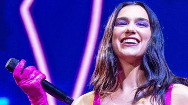 Dua Lipa smiles on stage, during a London date of her Future Nostalgia tour