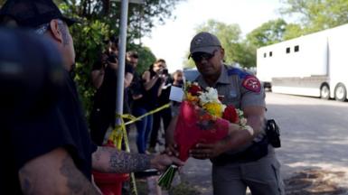 A police officer accepts flowers at Uvalde middle school