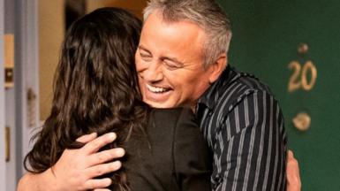 Courteney Cox and Matt LeBlanc embrace on the set of Friends: The Reunion