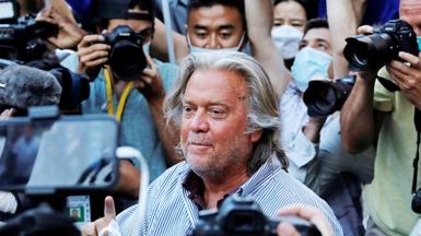 Steve Bannon stands outside court surrounded by photographers