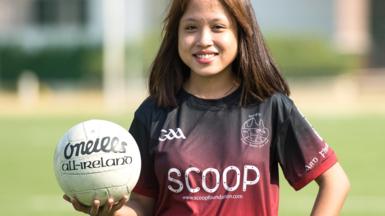 Sovann ThidaAva poses with a Gaelic football