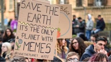 A protest sign about memes and the environment