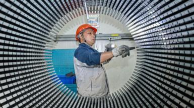 A worker checks a rotor core used for wind turbines at a factory in Nantong, in China's eastern Jiangsu province.