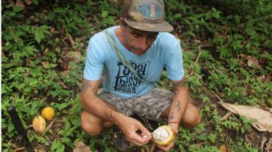 Javier Lijo holds up a cocoa pod