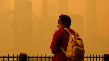 A person wears a face mask as smoke from wildfires in Canada cause hazy conditions in New York City on June 7, 2023