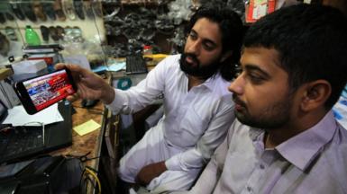 People in Peshawar watch the news of Mr Khan being granted bail at Islamabad High Court