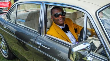 A man in a car at the Africa Concours d'Elegance event at Nairobi racecourse, Kenya - Sunday 24 September 2023