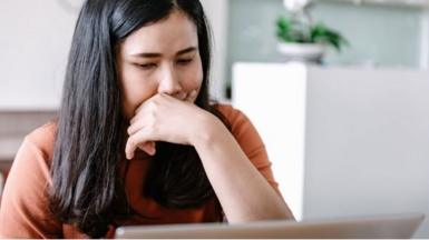 Woman looking intently at laptop