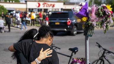 People gather at the scene of a mass shooting at Tops Friendly Market at Jefferson Avenue and Riley Street on Sunday, May 15, 2022 in Buffalo, NY