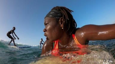 Khadjou Sambe surfs in the ocean