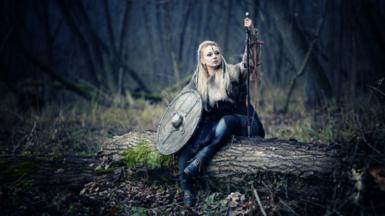 Female Viking sitting on a fallen tree