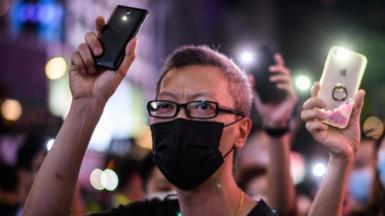 Pro-democracy protesters hold up their mobile phone torches as they sing during a rally in the Causeway Bay district of Hong Kong on June 12, 2020