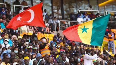 FEBRUARY 22: Senegalese people, holding the flags of Turkiye and Senegal, cheer during the opening of the Senegal Stadium in Dakar, Senegal on February 22, 2022. Senegal Stadium, which was built by a Turkish company in Senegal with a capacity of 50 thousand people, was opened with a ceremony attended by Turkish President Recep Tayyip Erdogan
