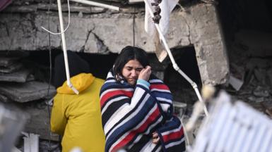 A woman cries as search and rescue efforts continue after 7.7 and 7.6 magnitude earthquakes hit Kahramanmaras
