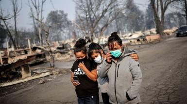 Sandra, Daniela, and Ester Reyes react while visiting their destroyed trailer home after the wildfires destroyed a neighbourhood in Bear Creek, Phoenix, Oregon