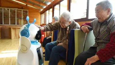 تصویر سه کهنسال در کنار یک روبات. در سال ۲۰۱۶ روبات‌های خدماتی «ای تای» در نظام رفاه اجتماعی هانگژو در چین مورد استفاده قرار گرفتند