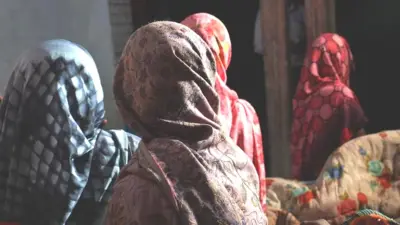 Women grieving the murdered girls at their home