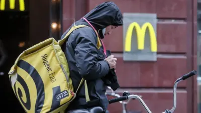 An employee of the Yandex.Eda food delivery service is seen by a McDonald's restaurant in central Moscow.