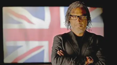 David Olusoga pictured in front of a Union Jack flag