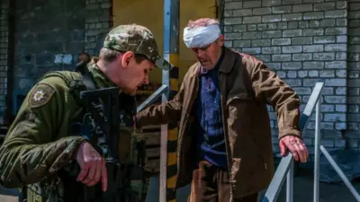 soldier helps civilian in Severodonetsk, 23 May