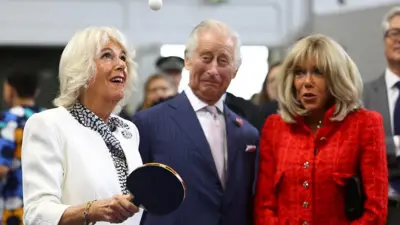 Queen Camilla plays table tennis next to King Charles and Brigitte Macron