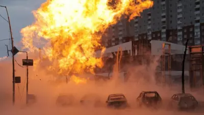 A huge fire is pictured above a row of cars after a Russian missile strike on Kyiv on 2 January