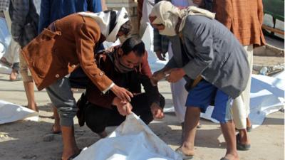 رجال ينقلون جثث قتلى الغارة التي استهدفت سجنا في صعدة شمالي اليمن