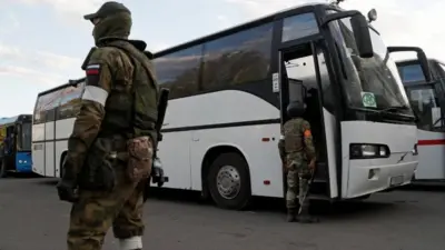 A photo purportedly showing pro-Russian troops standing in the village of Olenivka next to buses with Ukrainian fighters from Mariupol. Photo: 17 May 2022