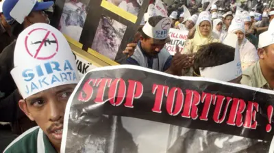 Para pengunjuk rasa menuntut penghentian penyiksaan terhadap warga sipil dalam konflik Aceh di depan Istana Presiden, pada 26 Juni 2002 silam.