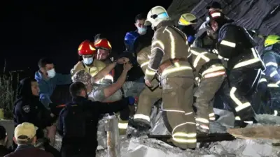 Emergency workers rescue a man from debris of a building Ukraine