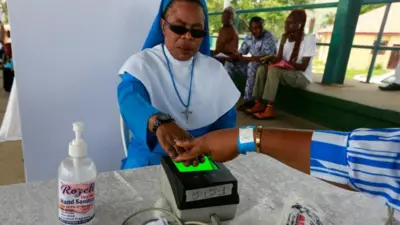Une sœur catholique se fait prendre ses empreintes digitales pendant l'exercice d'inscription des électeurs de l'INEC au centre Area 10 à Abuja, au Nigeria, le 23 juin.