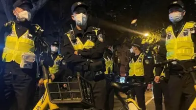 Policiais montam guarda durante manifestação contra restrições da covid-19 após incêndio mortal de Urumqi, em Xangai, China