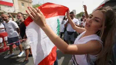 Lebanese expats dance as they queue to cast their votes for the May 15 legislative election at Lebanon's Consulate in the Gulf emirate of Dubai on May 8, 2022.