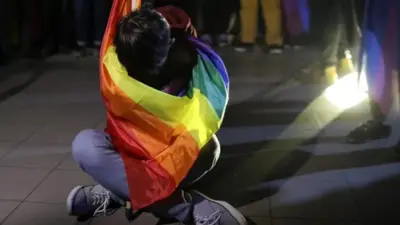 Demonstran diselimuti bendera pelangi, simbol perjuangan kelompok LGBT.